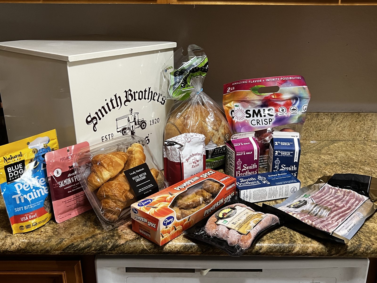 Smith Brothers grocery delivery box with milk, bread, bacon, and produce on a kitchen counter